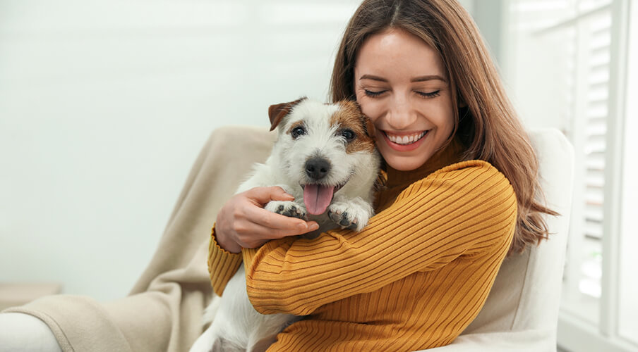a woman smiling holding her dog